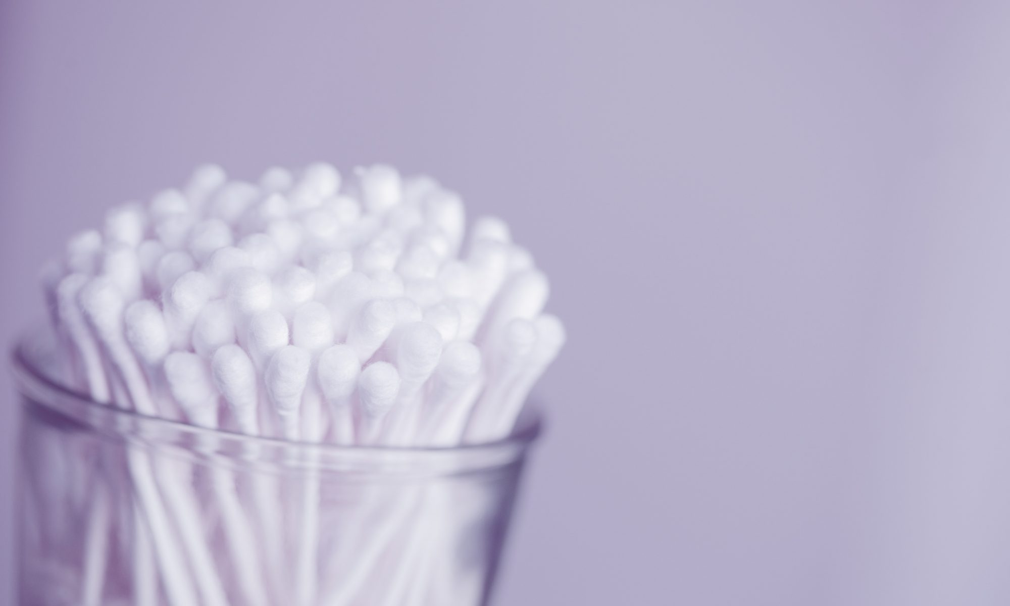 Jar of cotton buds with a lavender background