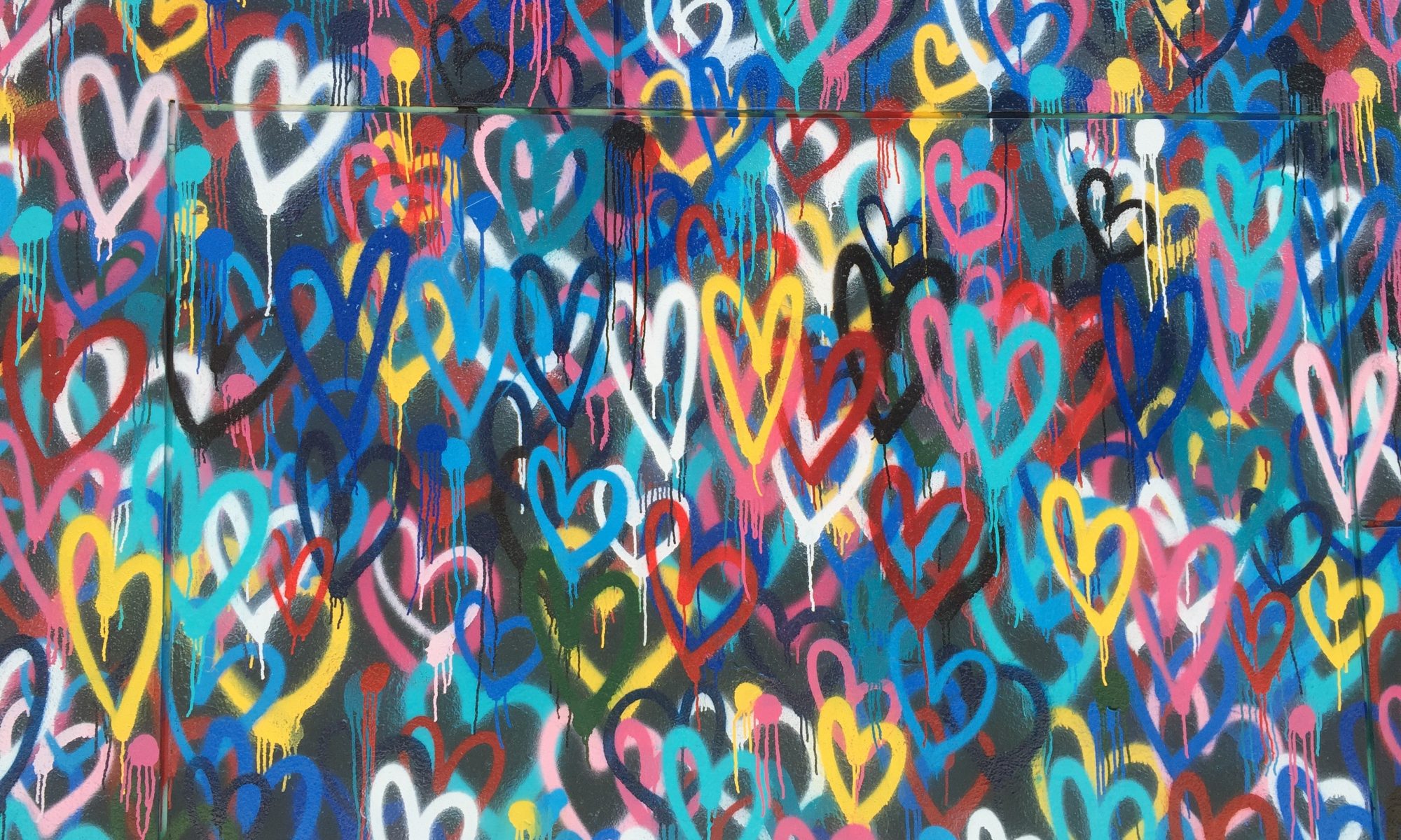 Wall of colour spray-painted hearts_Photo by Renee Fisher on Unsplash