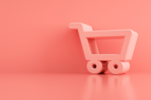 A toy shopping trolley against a pink background
